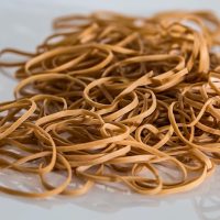 一位正在整理字帖与纸张的编辑手部特写，桌上分类摆放着不同规格的练习本，画面整洁有序